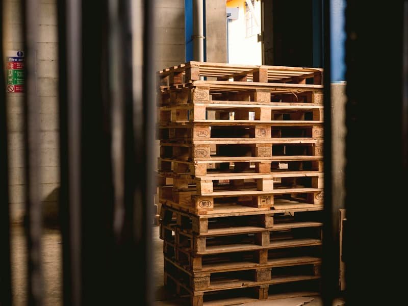 Stack of wooden pallets in low warehouse light