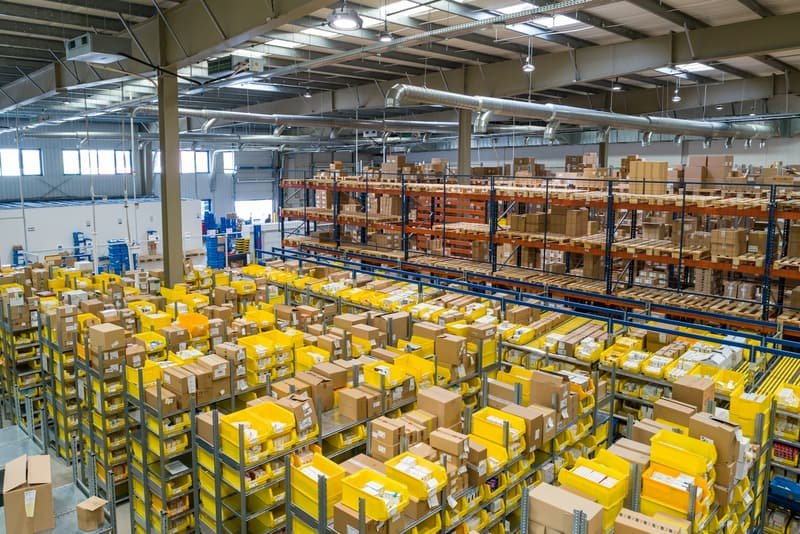 Warehouse shelving filled with sorted parcels and totes ready for despatch