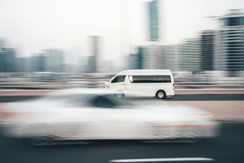 Courier van at speed through city streets, buildings blurred by motion