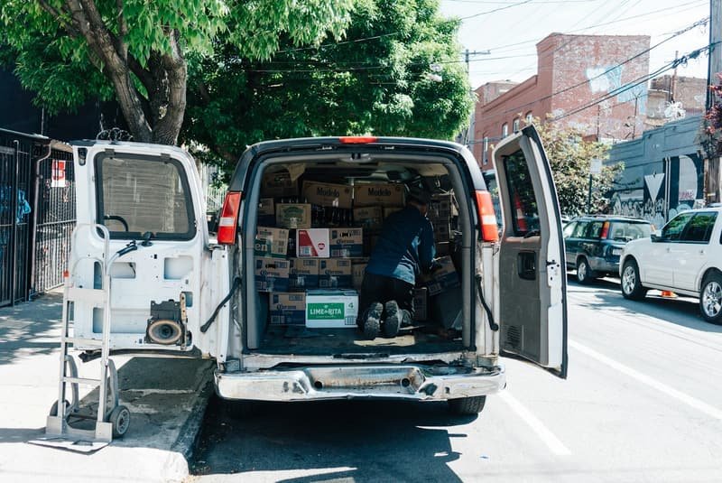 Van being unloaded at a venue with cases and boxed equipment