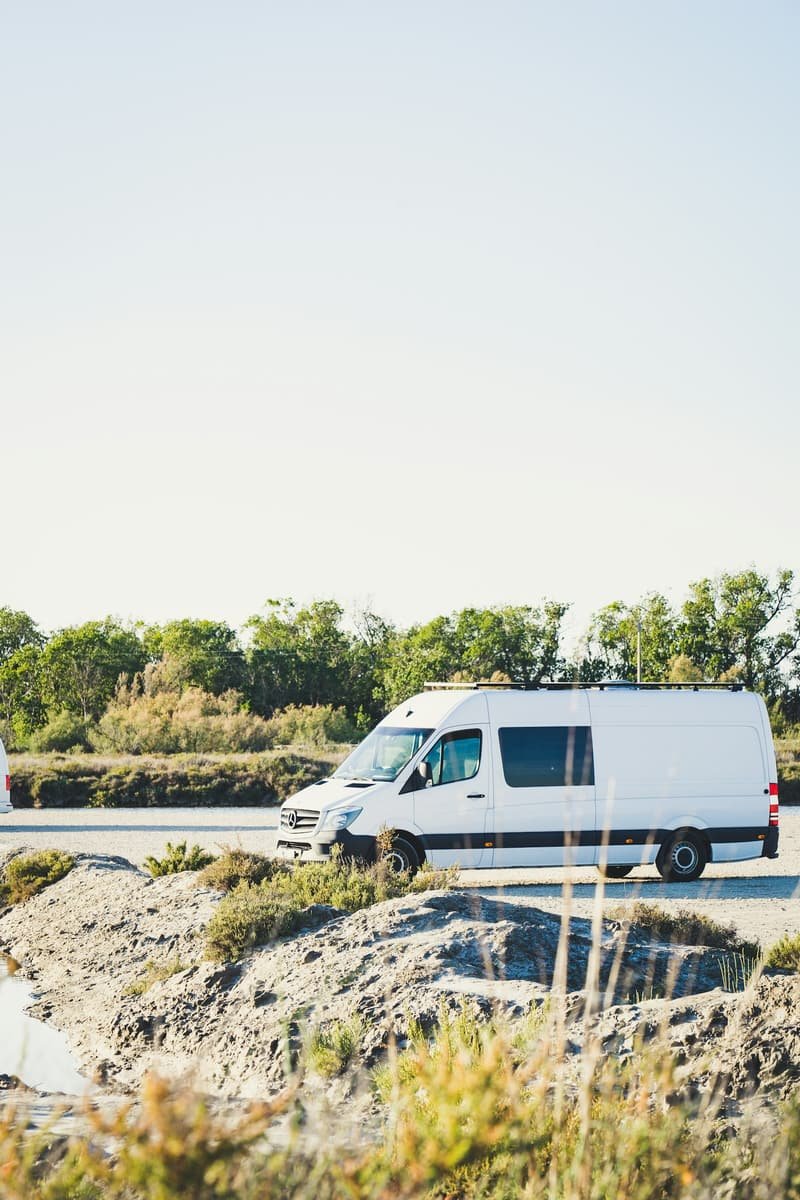 Clean white courier van on the open road between jobs