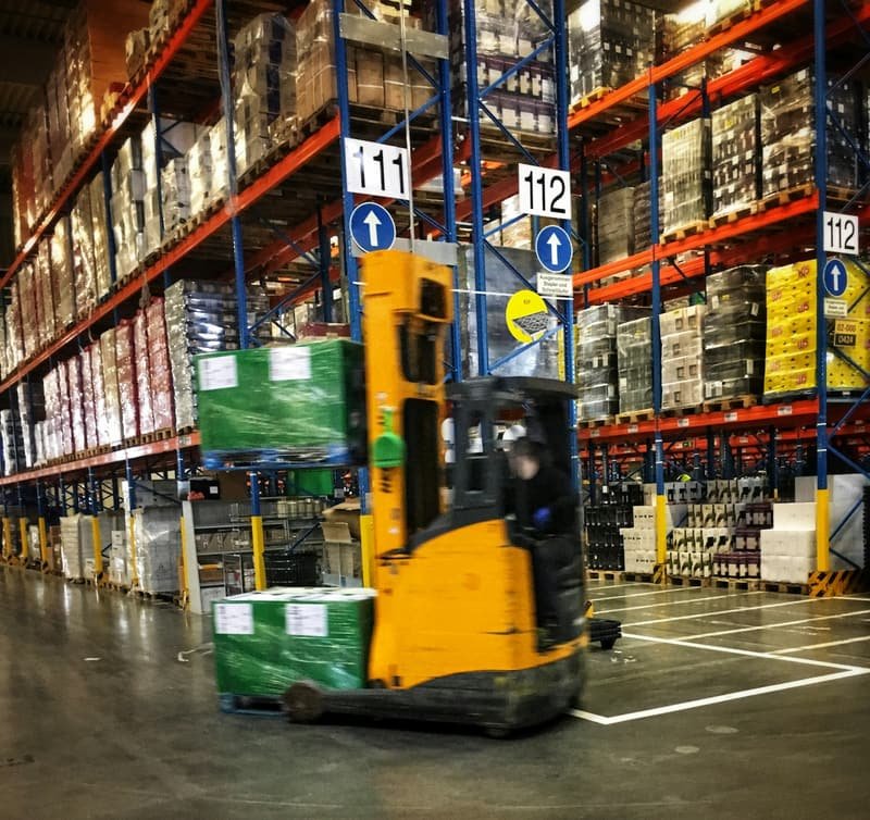 Picker moving stock through aisles of a retail distribution warehouse