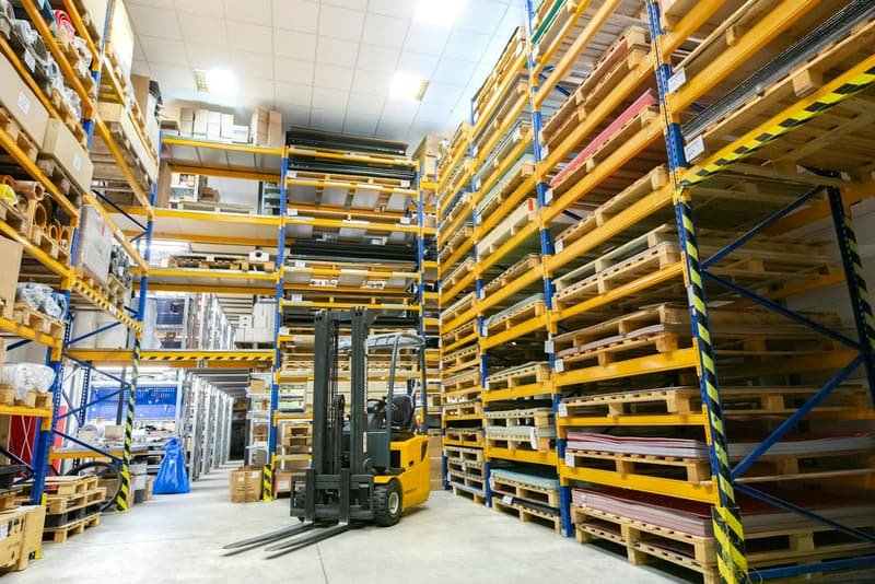 Tall warehouse racking loaded with palletised stock awaiting movement